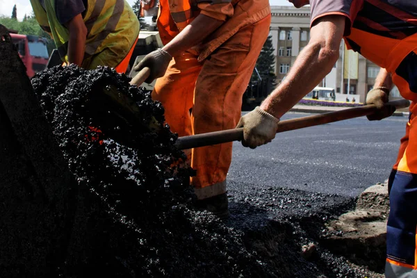Arbetare i orange Uniform är om varm asfalt på en stad Stree — Stockfoto