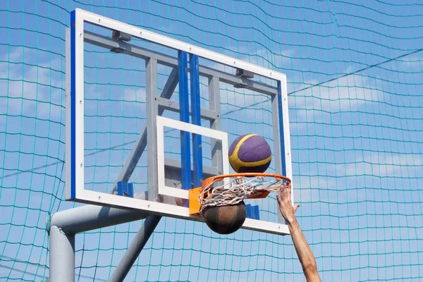 To bolde i en udendørs basketball kurv. Strikers hånd. Åbn - Stock-foto