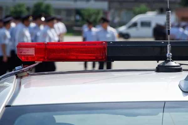 Luz intermitente roja y antena de un coche de policía en una calle de la ciudad —  Fotos de Stock