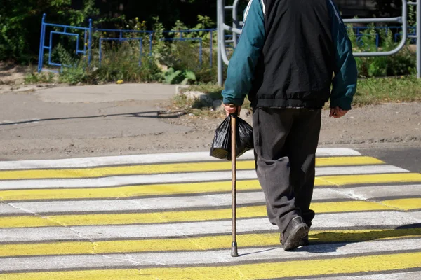 Senior Citizen-en äldre man med en käpp och en svart påse Cros — Stockfoto