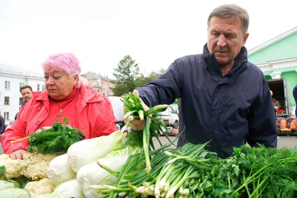 Shopper välja grönska på en jordbrukare jordbruksmässa. Town S — Stockfoto