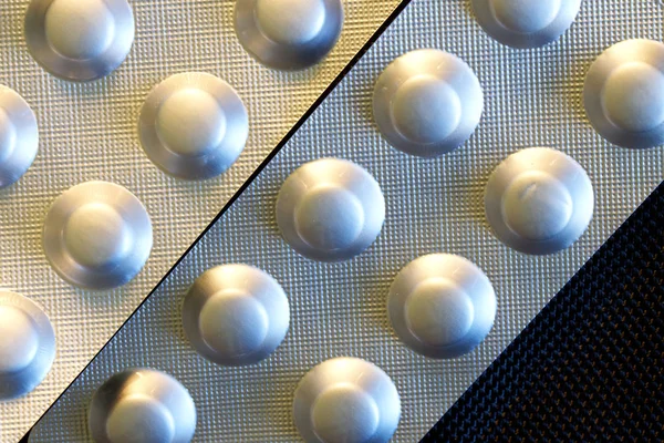 Μεταλλικές φουσκάλες με χάπια βρίσκονται σε σκοτεινό φόντο. Ιατρική, pH — Φωτογραφία Αρχείου