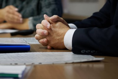 Toplantı ve karar sırasında patronun elleri. Sıkıştırılmış dosya