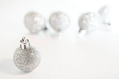 Beyaz bir yüzeyde gümüş gibi parlak Noel ağacı süslemeleri