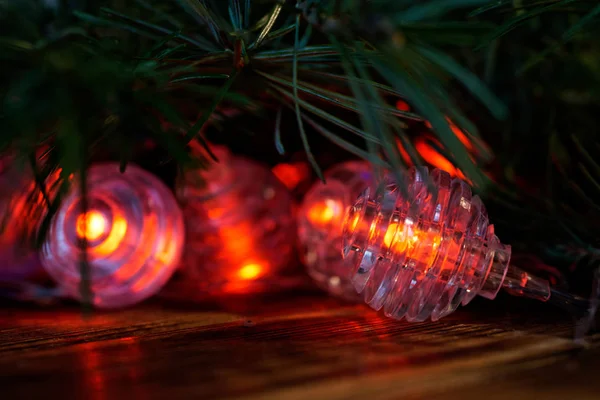 Les néons rouges à côté d'une branche d'arbre de Noël reposent sur un bois — Photo