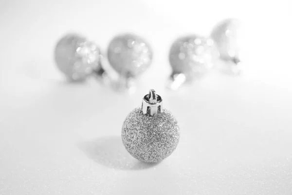 Silver Christmas decorations on a white surface imitating snow.