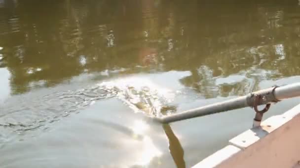 Primer plano, botes a su vez, remando con un remo. Reflejo de la luz solar por el agua . — Vídeos de Stock