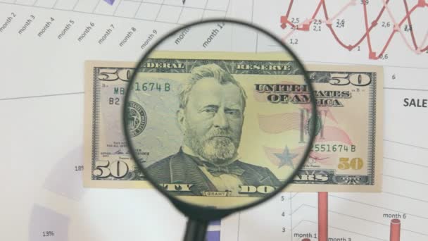 Studie van een bankbiljet vijftig dollar, verhogen met behulp van een vergrootglas. — Stockvideo