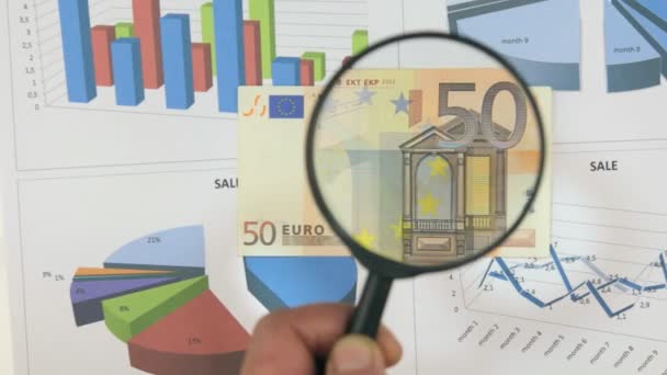 Изучение банкноты 50 евро, увеличивающейся с помощью увеличительного стекла . — стоковое видео