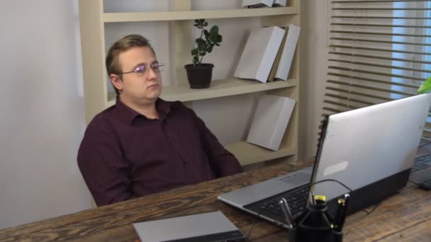 Tired businessman swinging on chair in office near laptop. — Stock Video