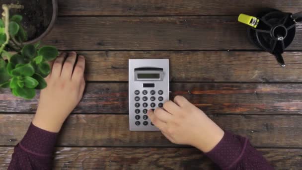 Vista dall'alto. Primo piano, uomo d'affari che lavora, contando su una calcolatrice sdraiato su un tavolo — Video Stock