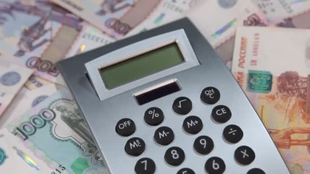 Close-up, a calculadora encontra-se em uma pilha de rublos. Rotação . — Vídeo de Stock