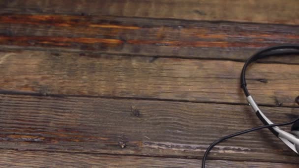 Headset lying on a vintage wooden table. Slider shot. — Stock Video