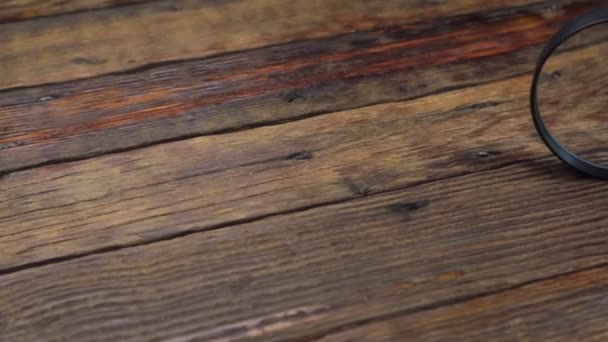 Lente d'ingrandimento su un tavolo in legno vintage. Slider colpo . — Video Stock