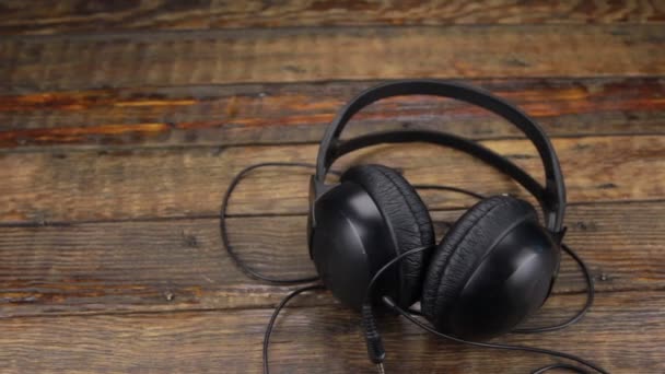 Slider shot, auriculares acostados en una mesa de madera vintage . — Vídeos de Stock