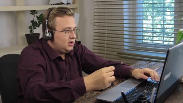 Lachende knappe klant support operator met headset werken in call center. — Stockvideo