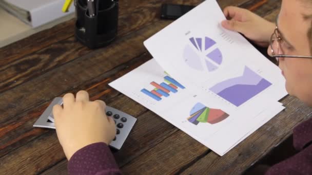 Podnikatel analyzuje grafy a spočítá Kalkulačka a navýšené karty, slaví vítězství. — Stock video