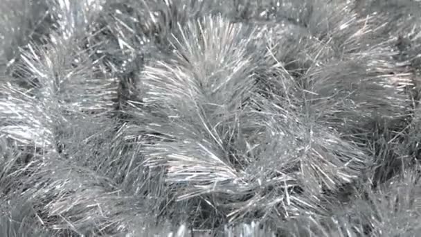 Close-up of the rotation of silver tinsel under the gusts of the wind. Christmas background, tinsel. — Stock Video