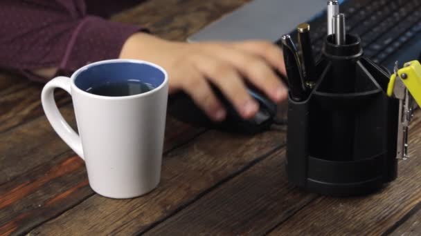 Крупним планом, напій з чашки, робота з комп'ютерною мишкою і клавіатурою ноутбука . — стокове відео