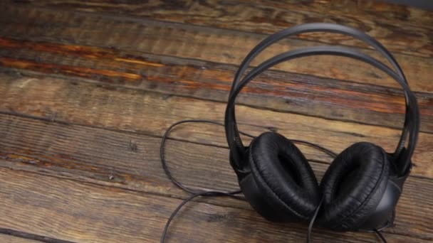 Panorama of headphones standing on a vintage wooden table. — Stock Video