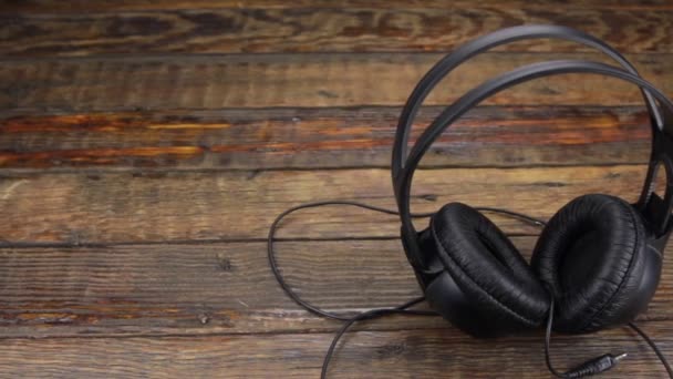 Slider shot, auriculares de pie sobre una mesa de madera vintage . — Vídeos de Stock