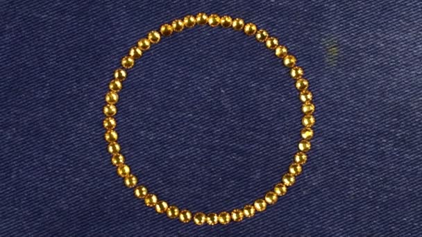 Rotazione di un cerchio fatto di strass gialli, simbolo dell'infinito. Vista dall'alto . — Video Stock