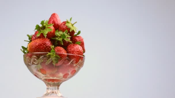 Drehung einer Glasvase mit einem Haufen roter Erdbeeren. — Stockvideo