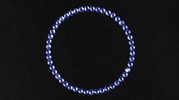 Rotatie van een cirkel gemaakt van blauwe steentjes, het symbool van oneindigheid. Bovenaanzicht. — Stockvideo