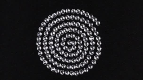 Rotación de una espiral hecha de diamantes de imitación de plata, el símbolo de la fuerza vital. Vista superior . — Vídeos de Stock