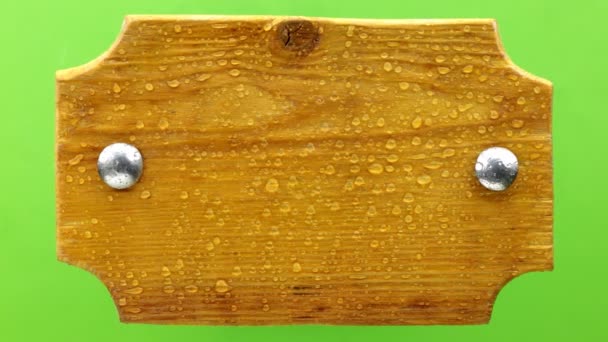 Vista superior. Gotas de agua cayendo sobre una tabla de madera con pernos de hierro. Aislado — Vídeo de stock