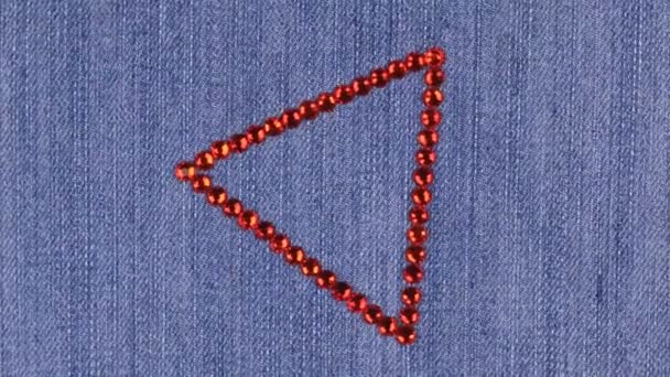 Rotation d'un triangle en strass rouge sur denim, le triangle symbolise l'achèvement . — Video