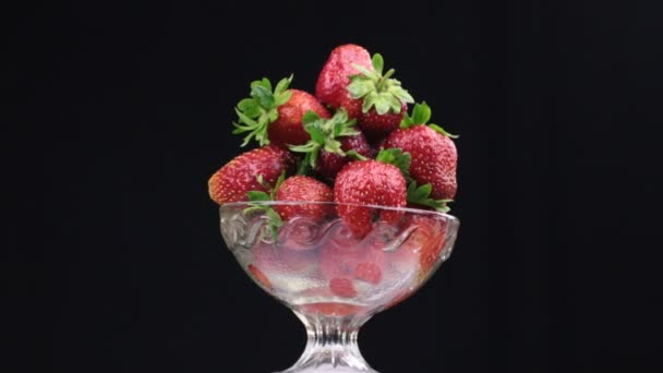 Rotation eines Haufens roter Erdbeeren, der in einer Glasvase liegt. — Stockvideo