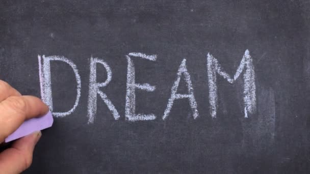 Word dream, written with chalk on blackboard. — Stock Video