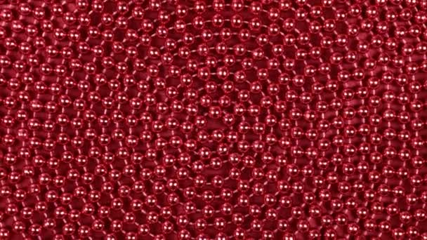 赤い布の上に横たわる赤いビーズの螺旋の回転. — ストック動画