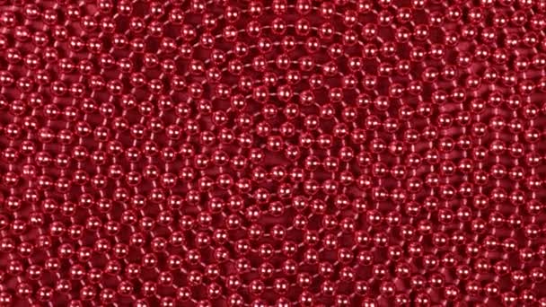 Rotation d'une spirale de perles rouges couchées sur un tissu rouge . — Video