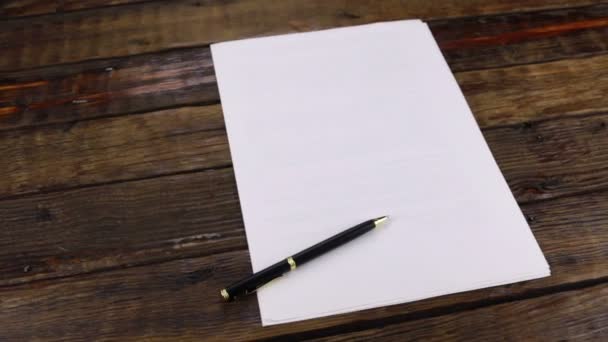 Περιστροφή, πένα που βρίσκεται σε ένα καθαρό φύλλο χαρτιού, με χώρο αντιγραφής. — Αρχείο Βίντεο
