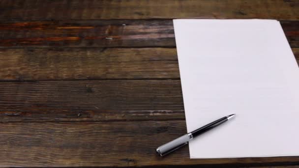 Snímek jezdce, pero ležící na čistém listu papíru s prostorem pro kopírování. — Stock video