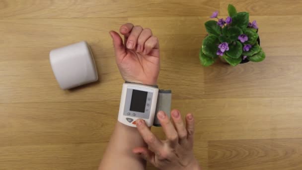 テーブルの血圧を測定する女性の手 — ストック動画