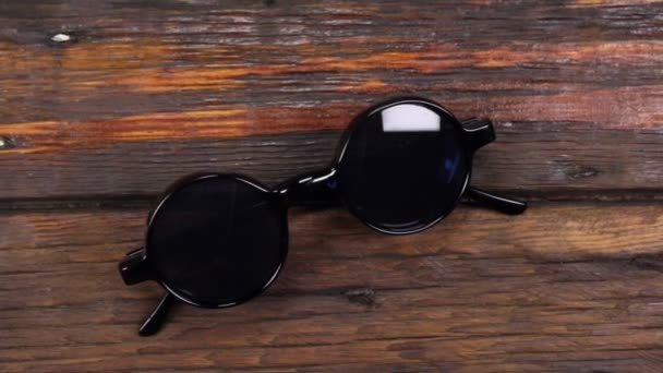 Guindaste de câmera, mesa de visão superior, mesa de madeira com óculos de sol hipster . — Vídeo de Stock
