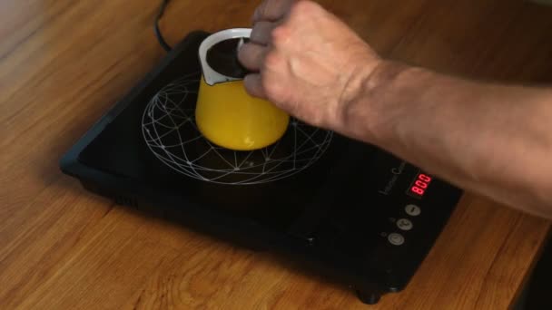 Человек делает кофе, регулируя мощность индукционной печи . — стоковое видео