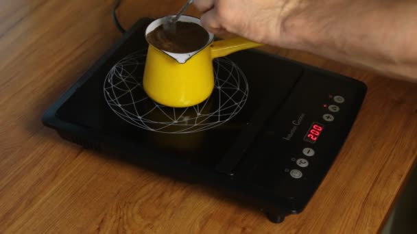 Людина робить каву, регулюючи потужність індукційної плити . — стокове відео
