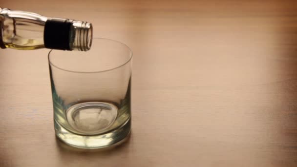 Az üvegről az asztalra öntött whisky