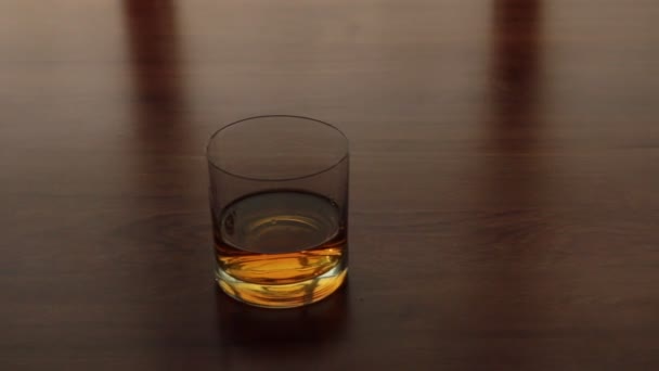 Panorama, szklany kieliszek z whisky stojący na stole kuchennym. — Wideo stockowe