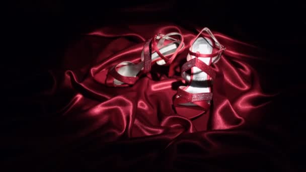 Sich nähernd, Paar rote Sandalen mit hohen Absätzen, die auf einem roten Tuch stehen. — Stockvideo