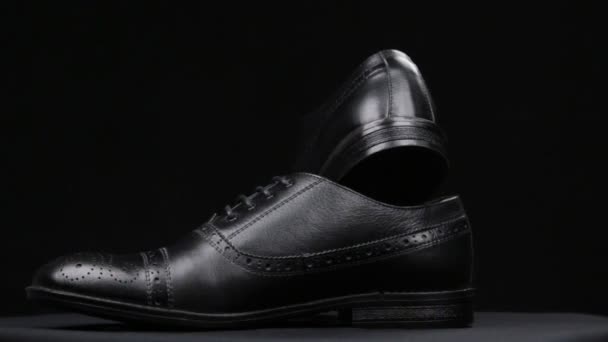 Rotation d'une paire de chaussures classiques sur fond noir . — Video