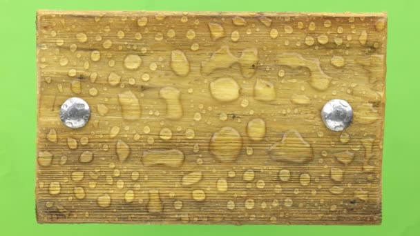Vento treme gotas de água em uma placa de madeira com parafusos de ferro, isolado . — Vídeo de Stock
