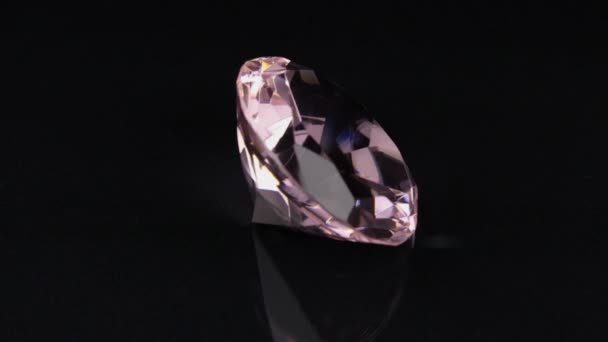 Rotación de un diamante de imitación transparente rosa sobre un fondo negro . — Vídeos de Stock