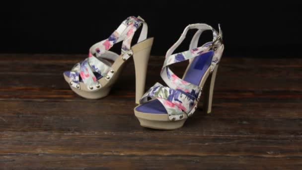 Beige sandals with high heels and a platform on a wooden background. — Stock Video