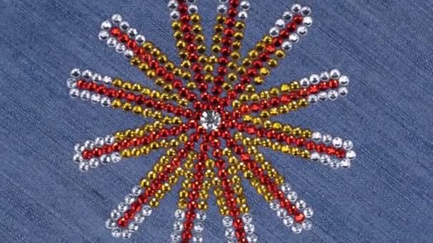 Rotation de strass multicolores disposés en forme d'étoile sur denim . — Video