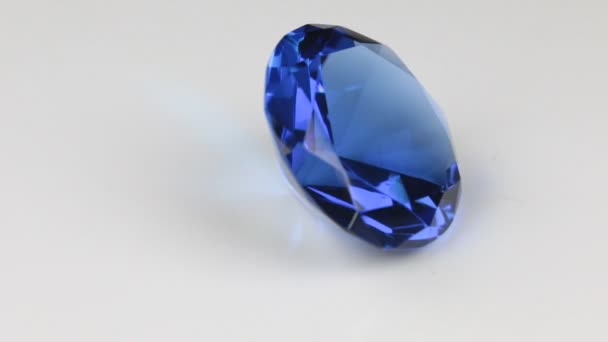 Rotación de un gran diamante azul sobre un fondo blanco . — Vídeo de stock